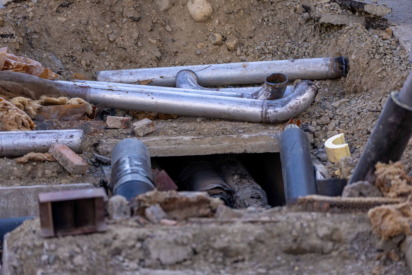 Excavated sewer line beside a house